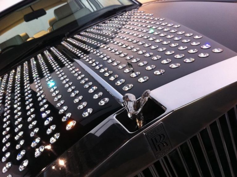 Luxury Rolls Royce car featuring a diamond-studded hood ornament and sparkling surface, showcasing opulence and elegance.