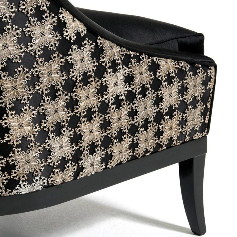 Black upholstered chair with intricate gold floral embroidery, showcasing elegant design and craftsmanship, perfect for stylish interiors.