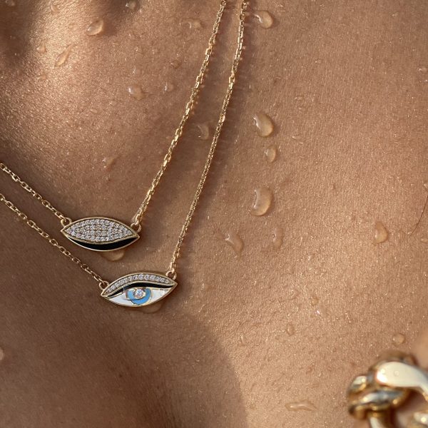 Gold necklaces featuring eye-shaped pendants with diamonds and a blue gemstone, showcasing elegant jewelry design.