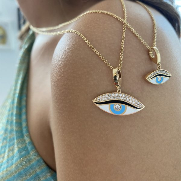 Gold eye charms necklace and earrings featuring blue and white enamel with sparkling accents, showcasing a unique jewelry design.
