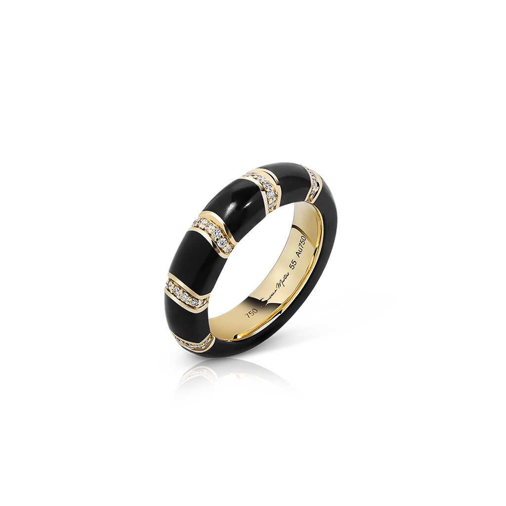 A black and gold band ring featuring diamond accents on a white background.