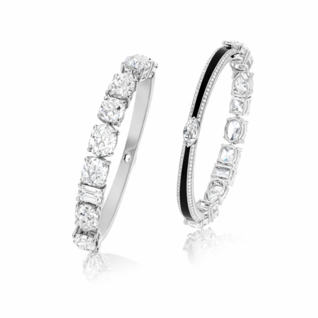 Two Art Deco style bangles featuring diamonds set in white metal with intricate designs.
