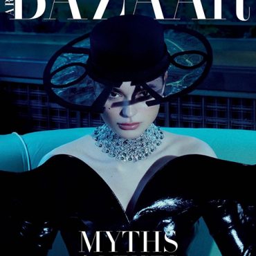 Harper's Bazaar magazine cover featuring a model in a black outfit and large hat, adorned with a statement necklace, showcasing high fashion.