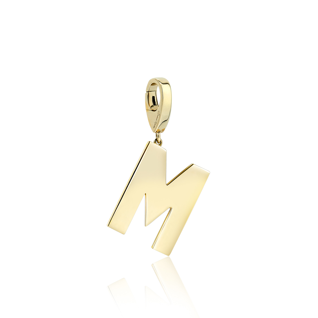 Gold charm in the shape of the letter M, featuring a polished finish and a loop for attachment.