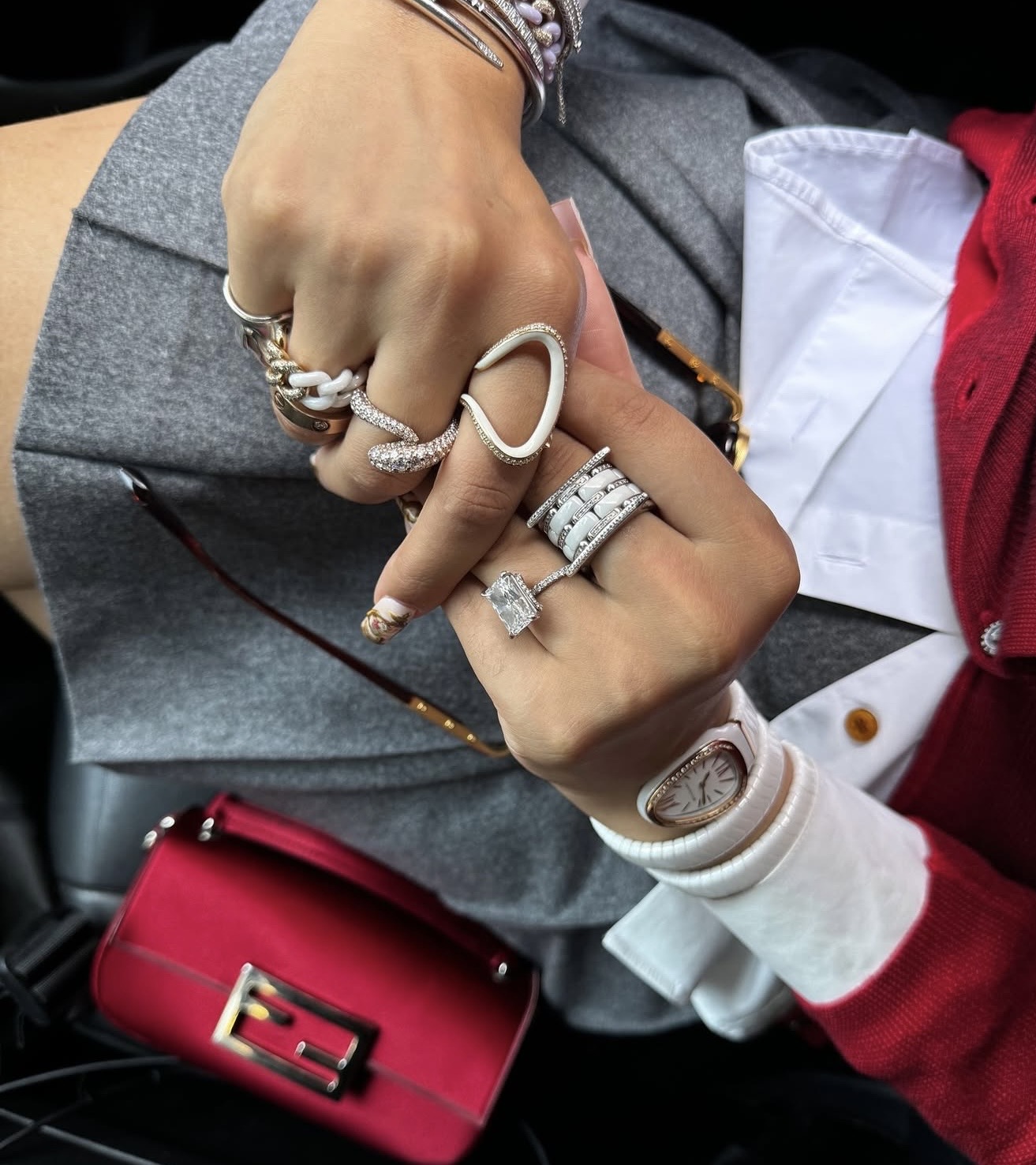 Multiple rings and bracelets worn on hands, showcasing intricate designs and materials.