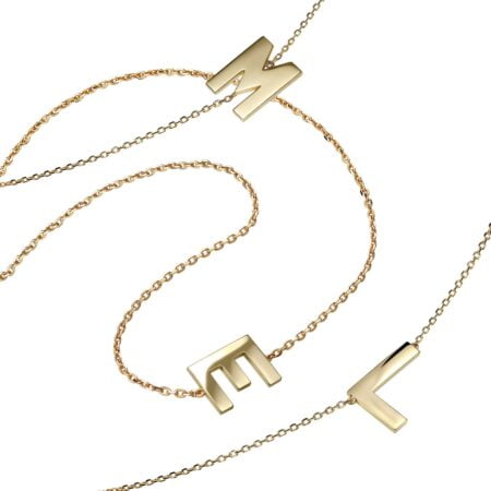 Gold necklace featuring the letters M, E, and L on delicate chains, showcasing a stylish and personalized jewelry piece.