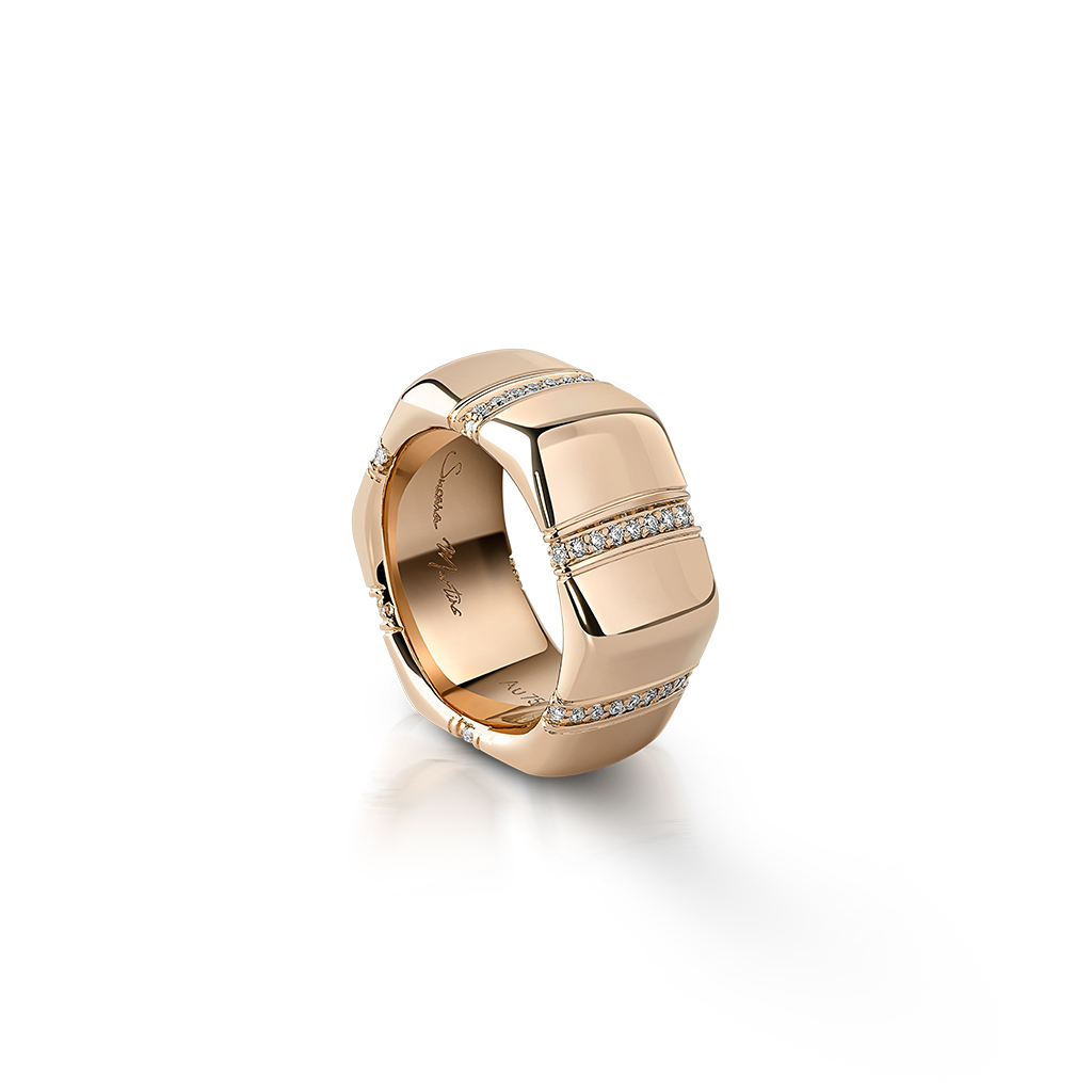 Gold ring with a geometric design and embedded diamonds on the surface.