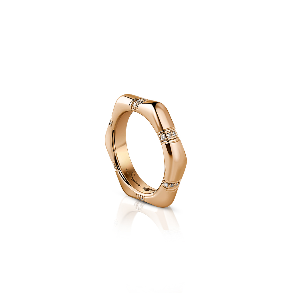 Gold ring featuring a geometric design with diamond accents set in the band.