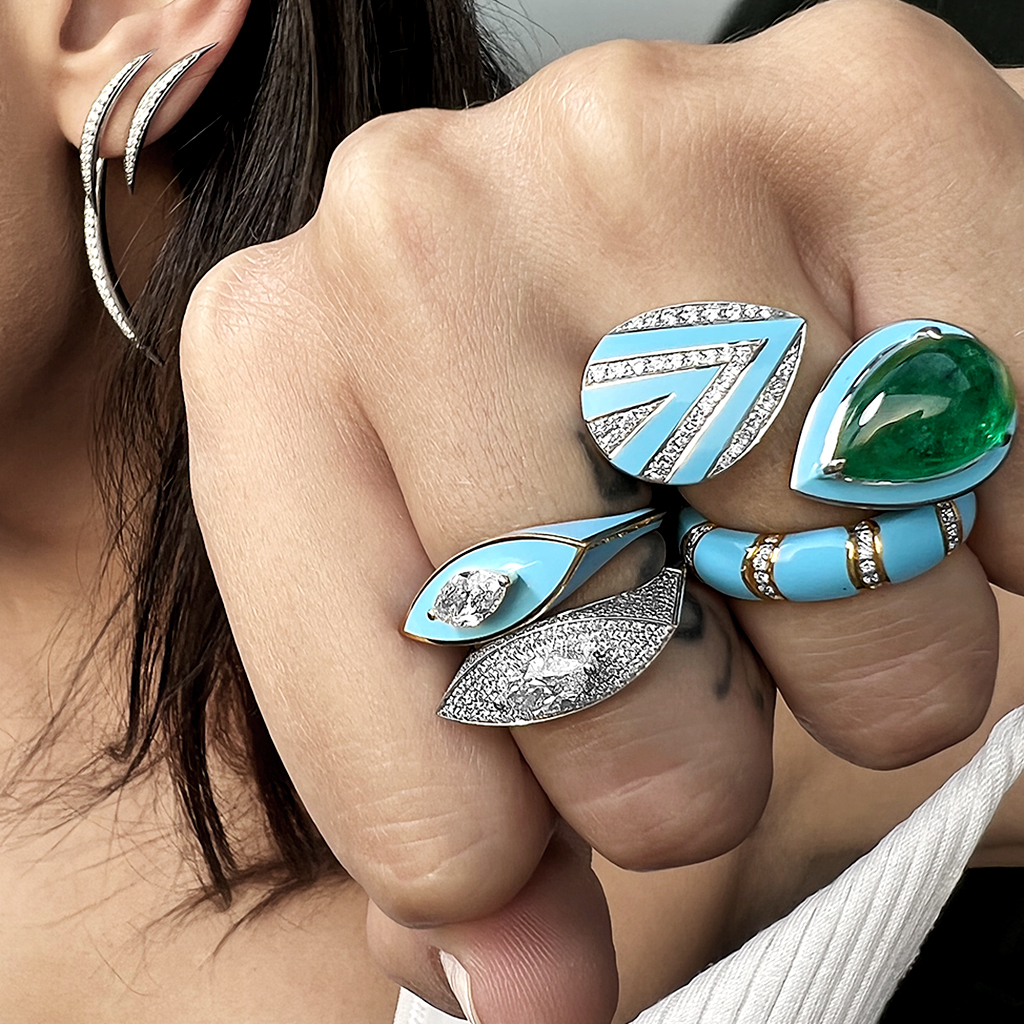 A close-up of a hand wearing multiple rings and an ear with a decorative earring.