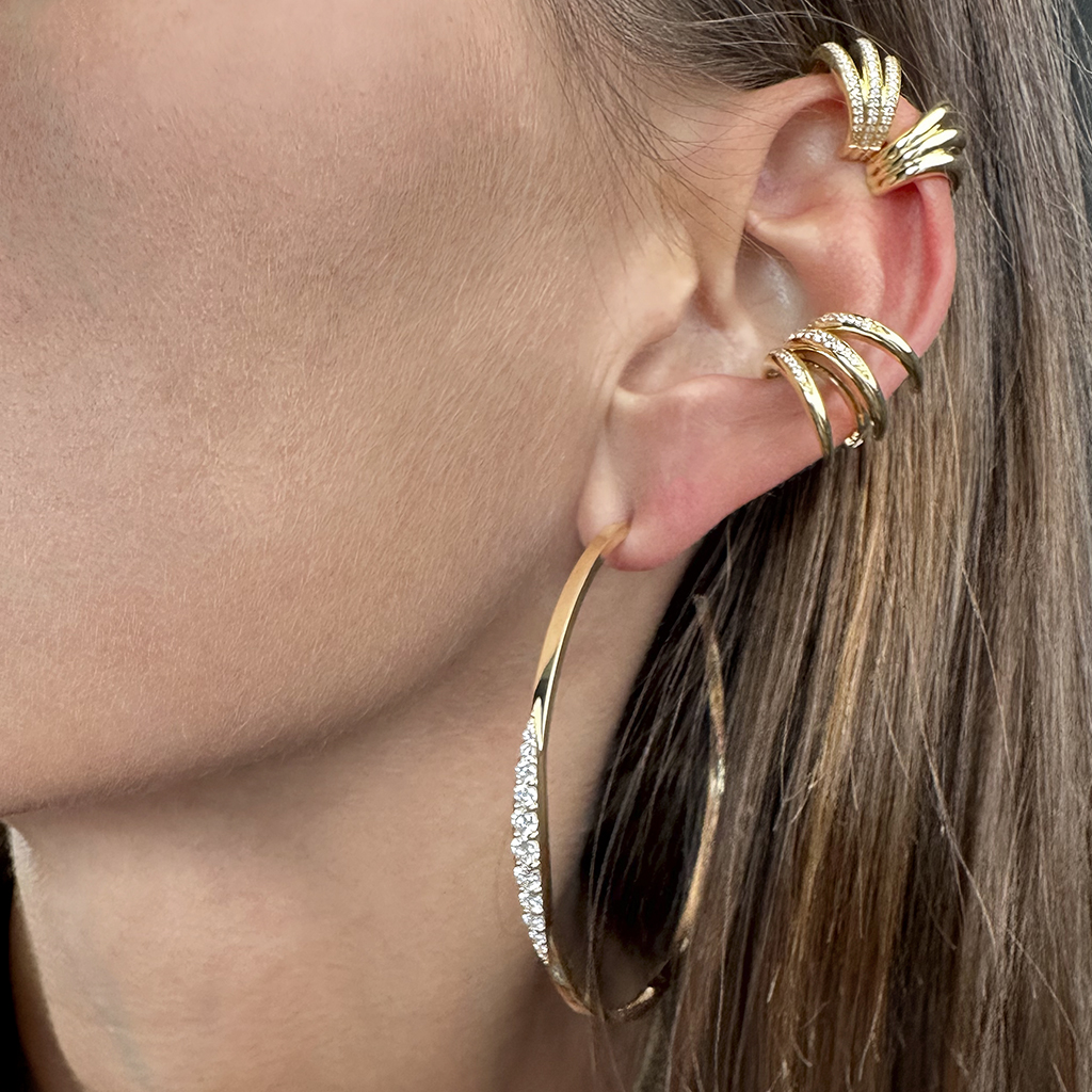 Gold hoop earrings and ear cuffs featuring sparkling accents, showcasing a stylish ear adornment look for modern fashion enthusiasts.
