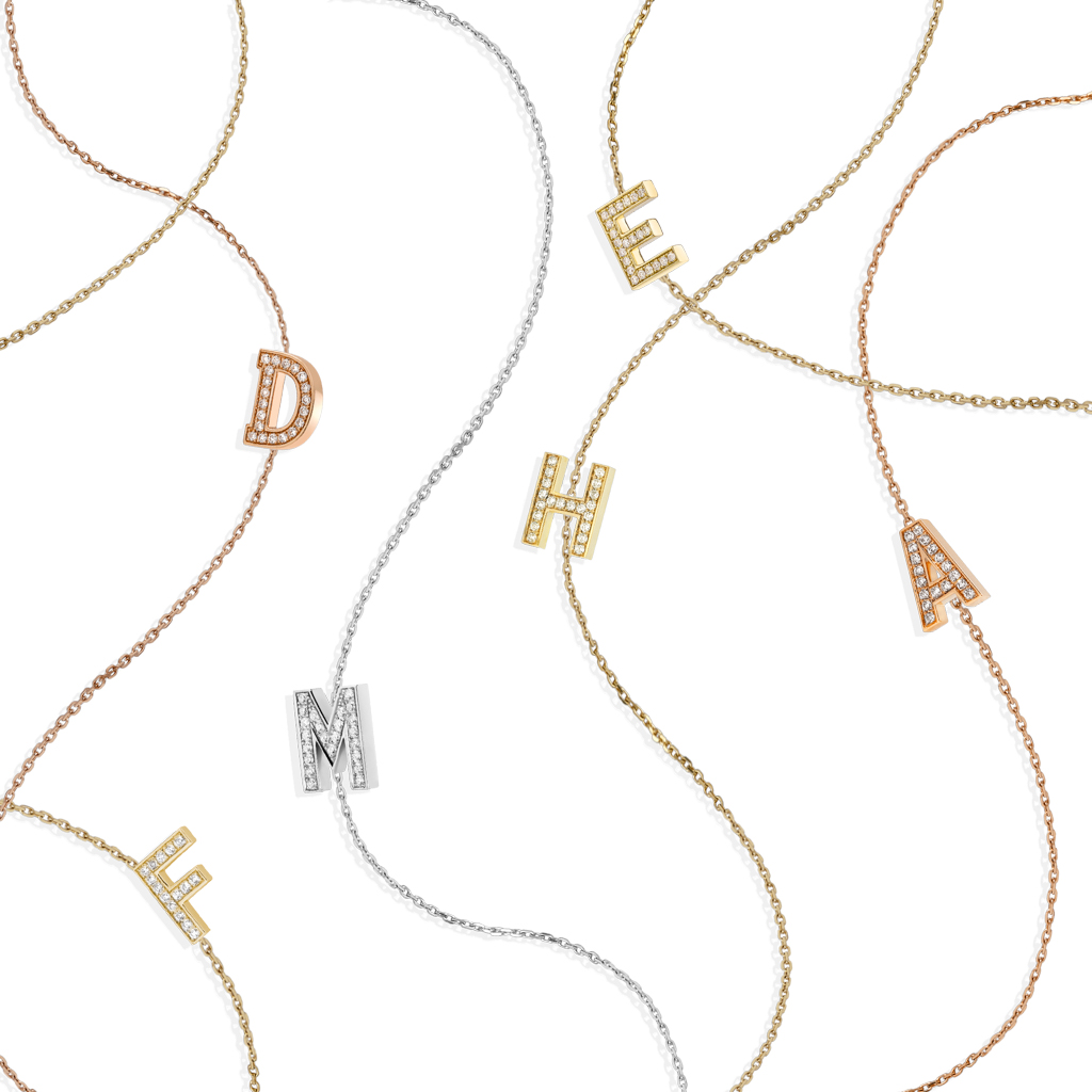A collection of Letter Mania sautoir necklaces featuring gold, silver, and diamond-encrusted letters on delicate chains.