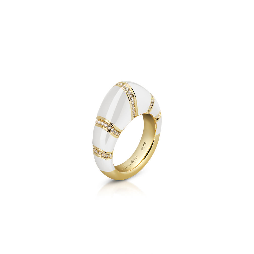 Gold dome ring with white enamel and diamond accents on the surface.