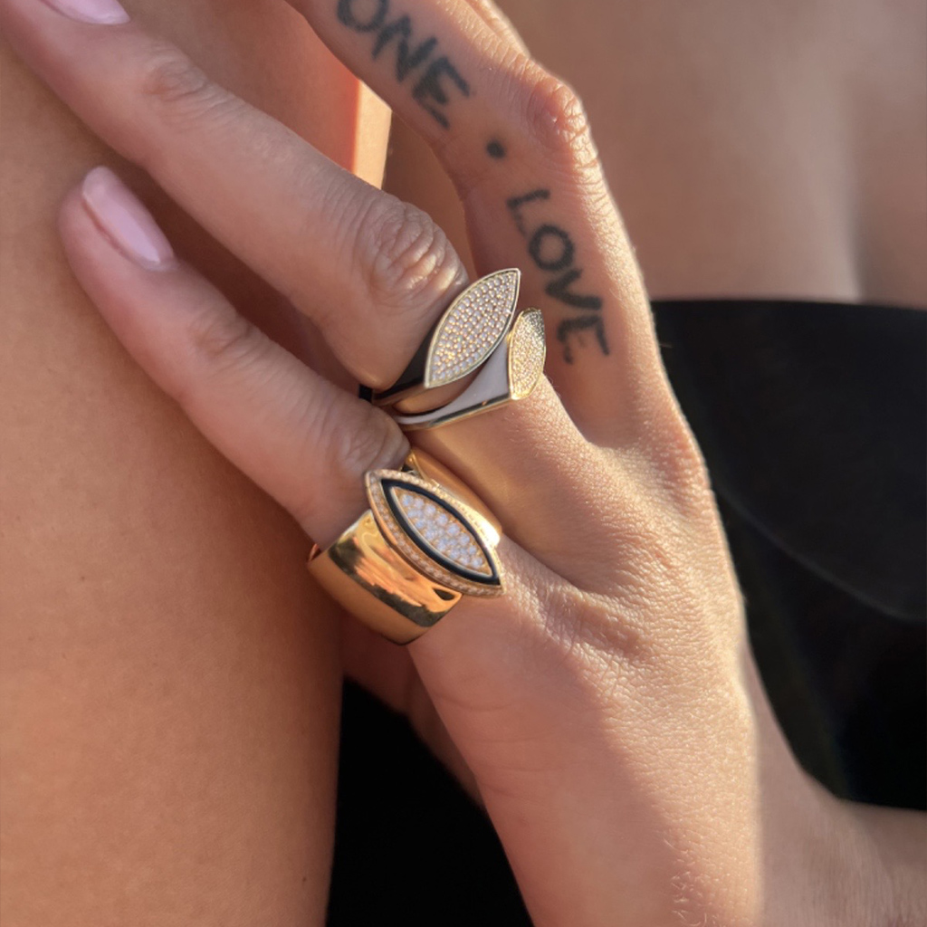 Maxi USTP black and gold rings with sparkling details worn on fingers, showcasing elegant jewelry design.