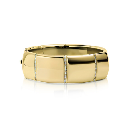 Gold bangle bracelet featuring diamond accents along the surface in a smooth design.