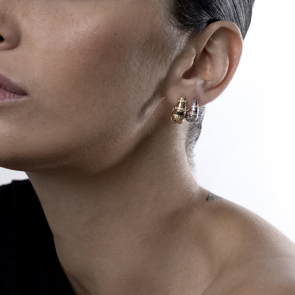 Model wearing gold and silver hoop earrings, showcasing the jewelry design and style.