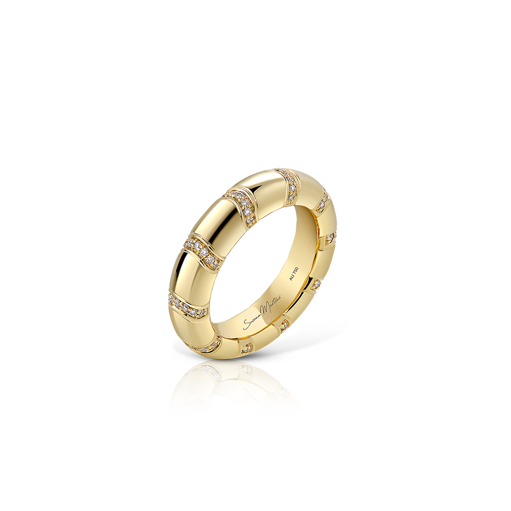 Gold band ring featuring diamond accents arranged in a pattern around the band.