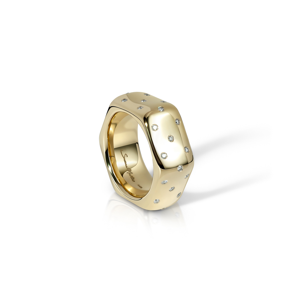 Yellow gold ring with polka dot design and embedded gemstones, showcasing a smooth finish.