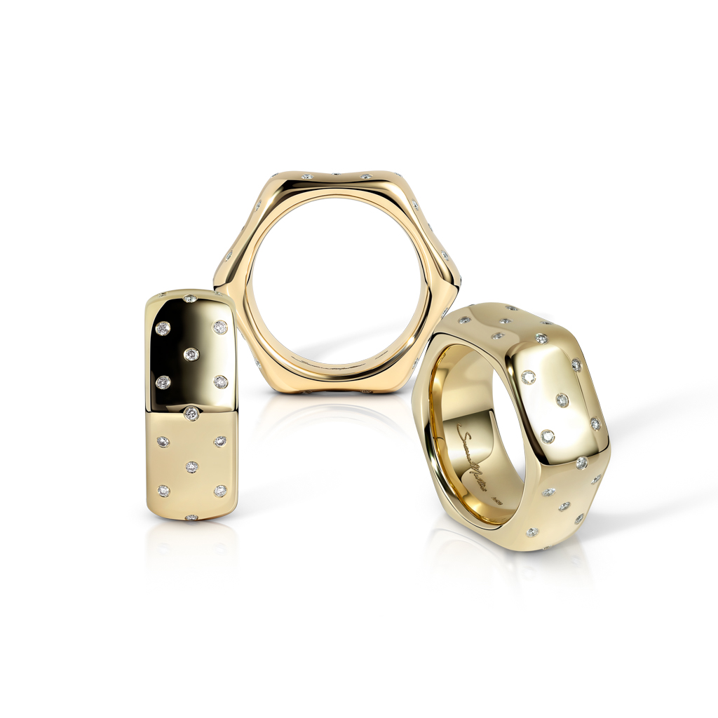 Three gold rings with polka dot designs and embedded gemstones arranged together.